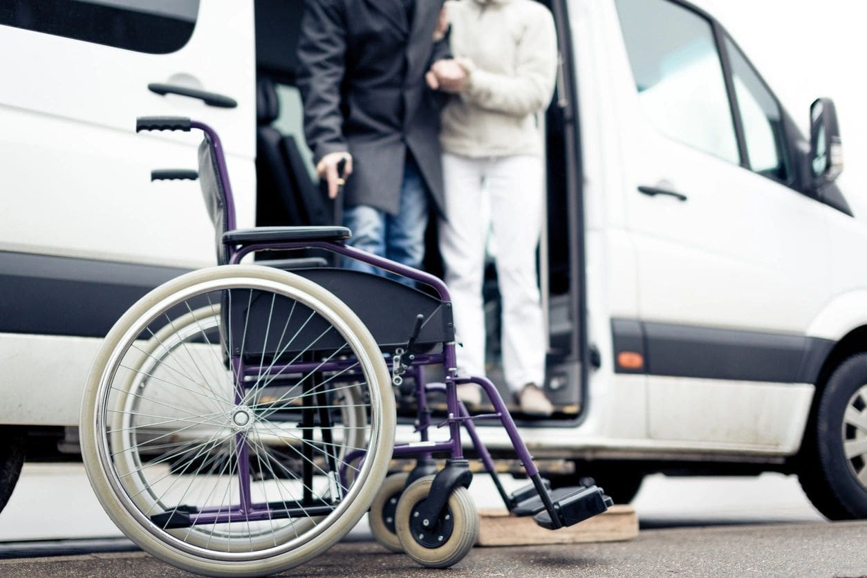 A wheelchair is parked in front of the van.